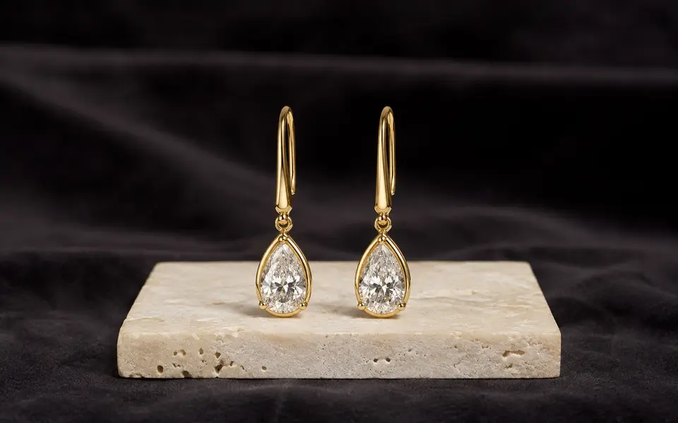 Pair of pear cut diamond drop earrings in yellow gold