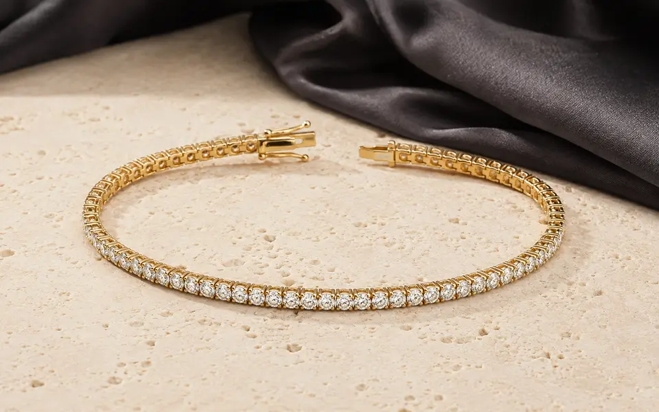 Yellow gold diamond tennis bracelet on warm ivory stone