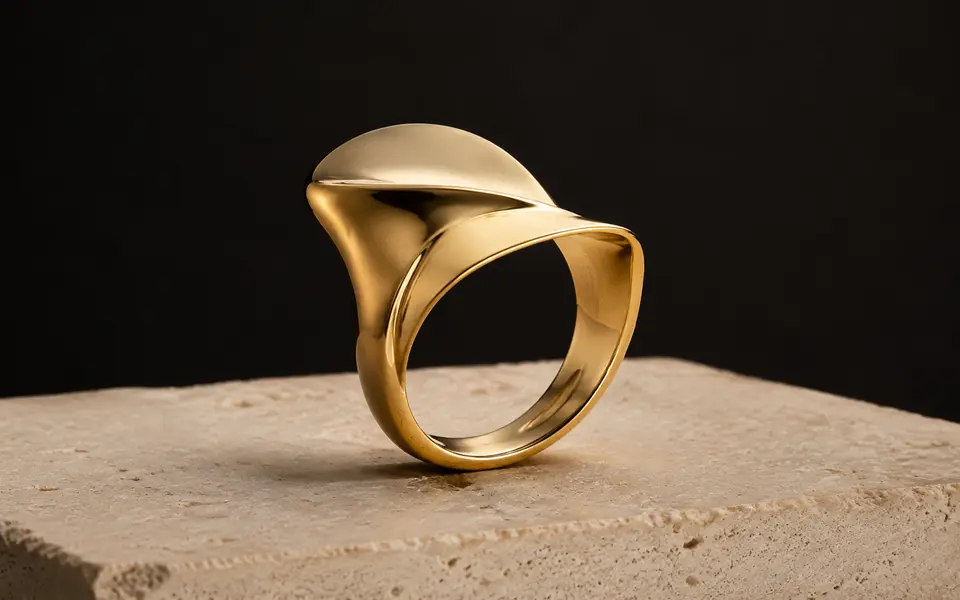 Modern sculpted yellow gold ring on an ivory stone plinth